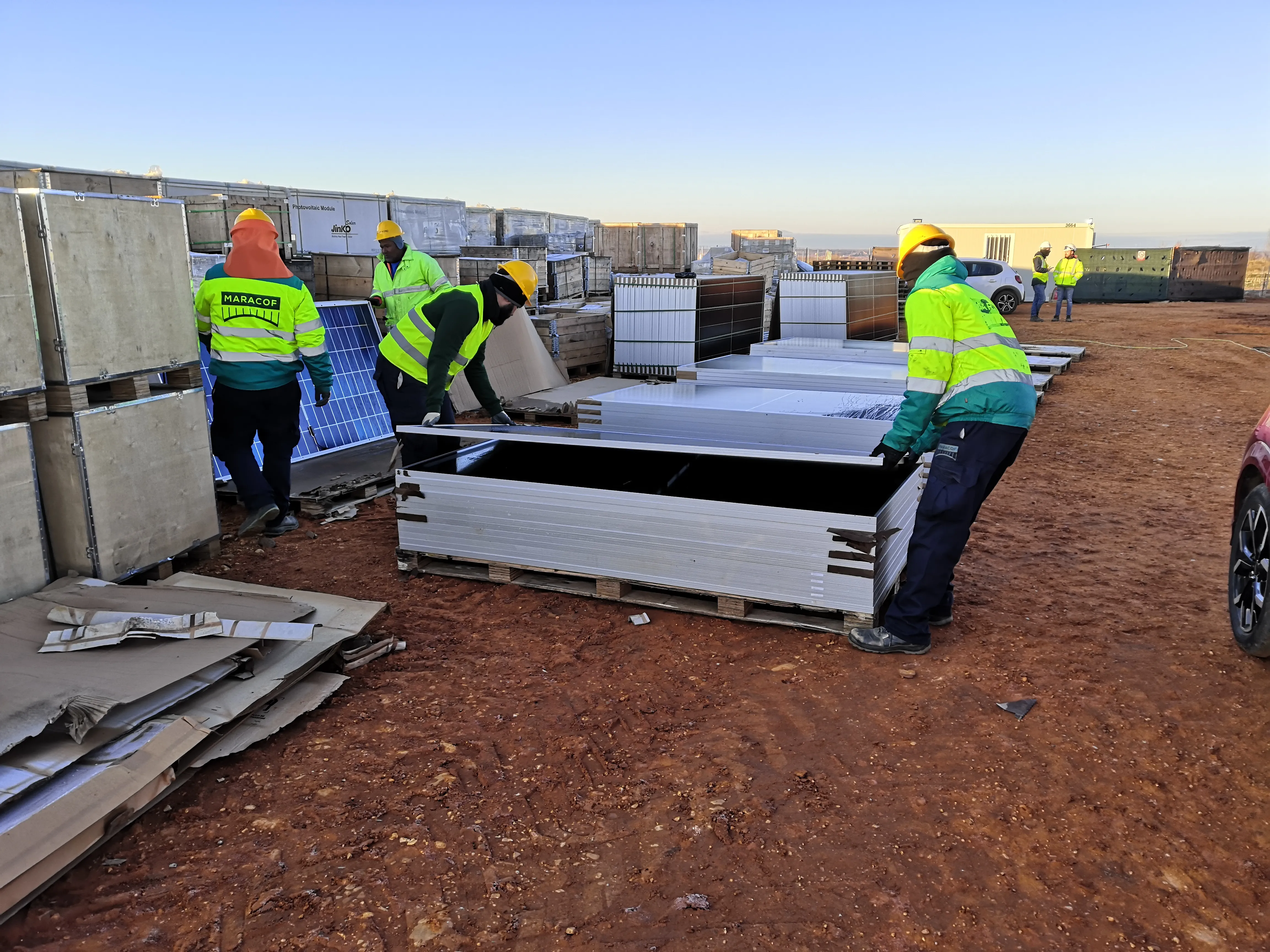 Workers lifting PV modules in preparation of electroluminescence inspection