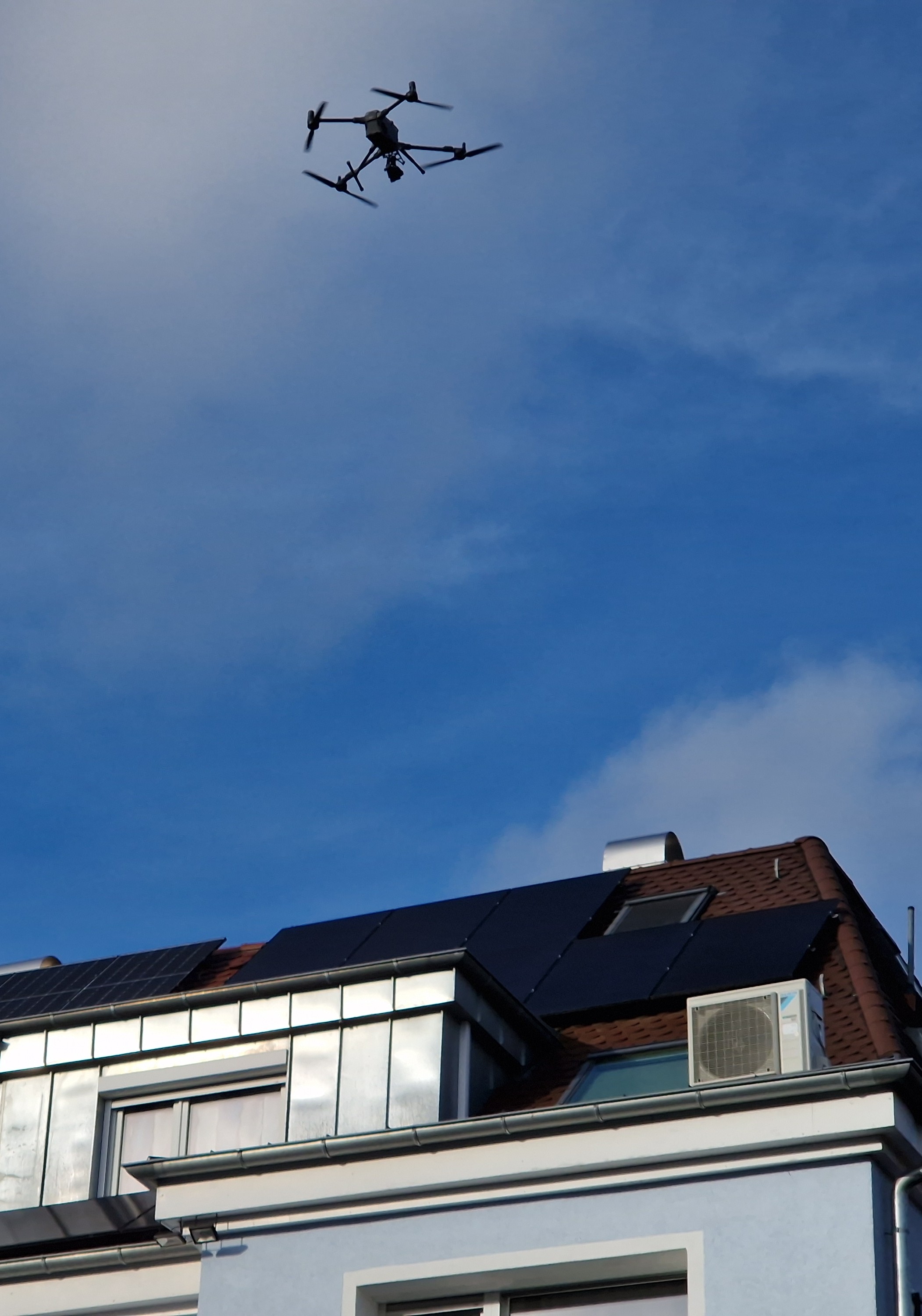 Drohne schwebt zur Inspektion über einem Haus nach Hagel